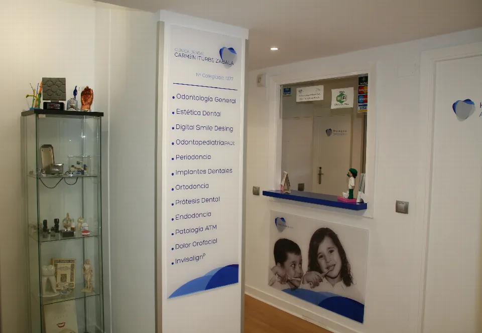 La entrada de la clínica, con una vitrina, el rótulo de las especialidades y la ventanilla de recepción