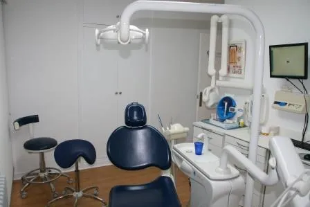 Un gabinete, con el sillón azul, la lámpara y una pantalla