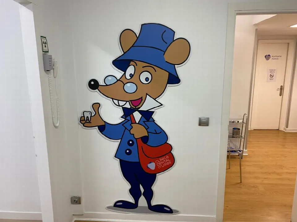 El Ratoncito Pérez dibujado en la pared del pasillo, con una bolsa que lleva el nombre de la clínica