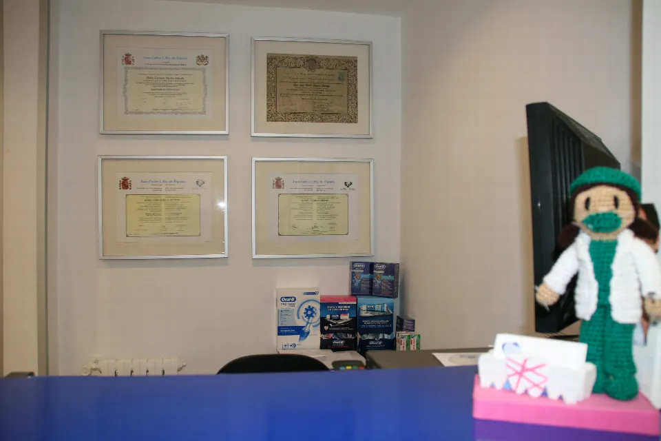 El mostrador de recepción, con los diplomas enmarcados detrás y un dentista de ganchillo encima